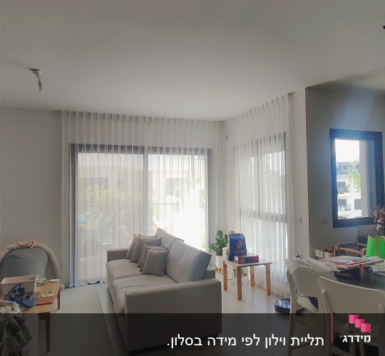 סלון עם וילונות לבנים על חלונות גדולים